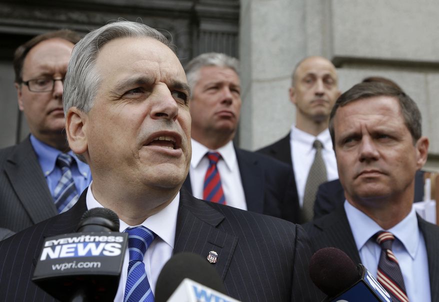 U.S. Attorney Peter Neronha, front left, responds to questions from reporters outside federal court, June 11, 2015, in Providence, R.I. A major Rhode Island landlord whose tenants have long complained about lead hazards, rodent infestations and other problems was sued Tuesday, June 6, 2023 by the state attorney general, Peter Neronha, who said conditions at many of the properties put renters' health and safety at risk. (AP Photo/Steven Senne) **FILE**