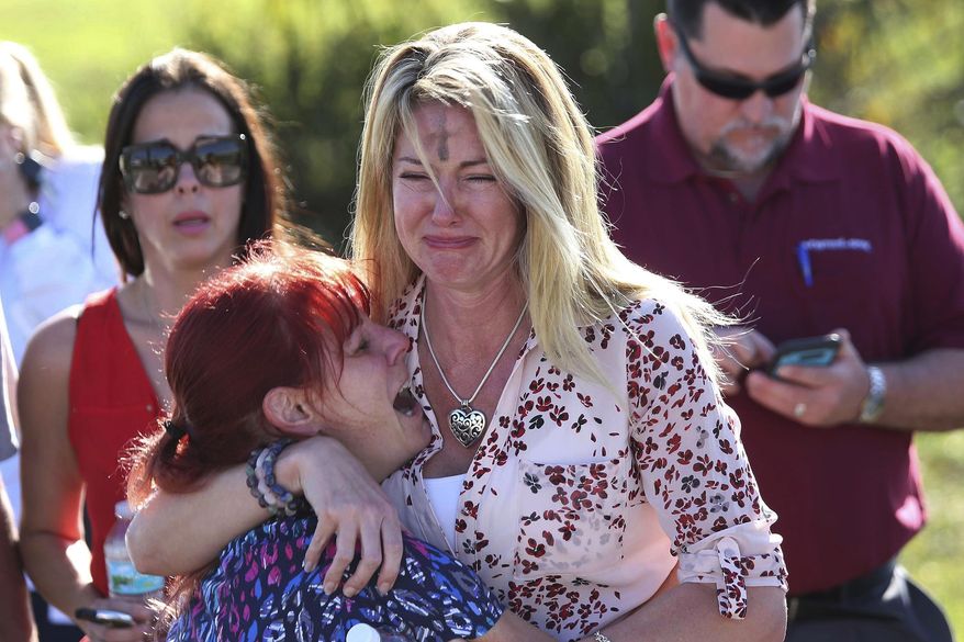 FILE - Parents wait for news after a reports of a shooting at Marjory Stoneman Douglas High School in Parkland, Fla., on Wednesday, Feb. 14, 2018. The Vegas Golden Knights and Florida Panthers were connected by tragedy five years before meeting in the Stanley Cup Final. Both teams helped their communities recover after the 2017 Las Vegas Strip shooting that left 60 dead and the 2018 massacre of 17 at Marjory Stoneman Douglas High School in Parkland. (AP Photo/Joel Auerbach, File)