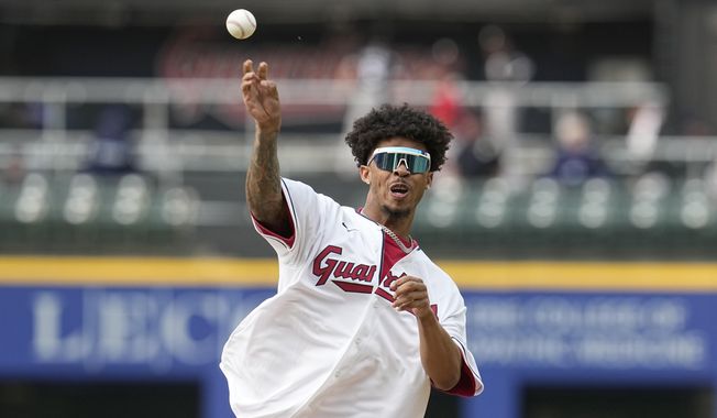 Cleveland Browns cornerback Greg Newsome II throws out a ceremonial first pitch before a baseball game between the Chicago White Sox and the Cleveland Guardians, Monday, May 22, 2023, in Cleveland. (AP Photo/Sue Ogrocki)