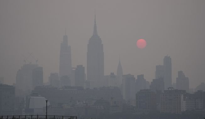 The sun rises over a hazy New York City skyline as seen from Jersey City, N.J., Wednesday, June 7, 2023. Intense Canadian wildfires are blanketing the northeastern U.S. in a dystopian haze, turning the air acrid, the sky yellowish gray and prompting warnings for vulnerable populations to stay inside. (AP Photo/Seth Wenig)