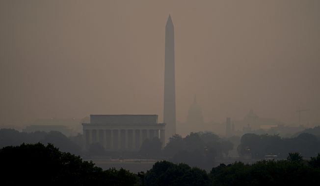 Haze blankets over monuments on the National Mall in Washington, Wednesday, June 7, 2023, as seen from Arlington, Va. Smoke from Canadian wildfires is pouring into the U.S. East Coast and Midwest and covering the capitals of both nations in an unhealthy haze. (AP Photo/Julio Cortez)