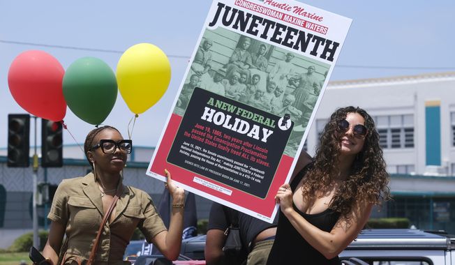 People hold a sign in their car during a car parade to mark Juneteenth on June 19, 2021, in Inglewood, Calif. Communities all over the country will be marking Juneteenth, the day that enslaved Black Americans learned they were free. For generations, the end of one of the darkest chapters in U.S. history has been recognized with joy in the form of parades, street festivals, musical performances or cookouts. Yet, the U.S. government was slow to embrace the occasion. (AP Photo/Ringo H.W. Chiu, File)