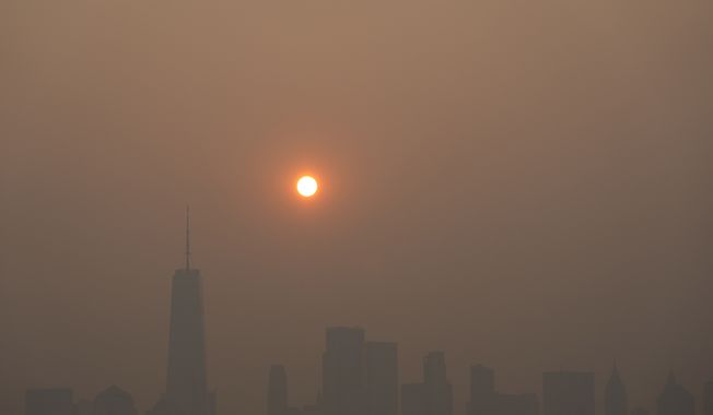 The sun rises over a hazy Manhattan skyline as seen from Jersey City, N.J., Thursday, June 8, 2023. Intense Canadian wildfires are blanketing the northeastern U.S. in a dystopian haze, turning the air acrid, the sky yellowish gray and prompting warnings for vulnerable populations to stay inside. (AP Photo/Seth Wenig)