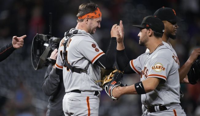 San Francisco Giants catcher Patrick Bailey, left, and right fielder Michael Conforto celebrate the team&#x27;s win in a baseball game against the Colorado Rockies on Wednesday, June 7, 2023, in Denver. (AP Photo/David Zalubowski)