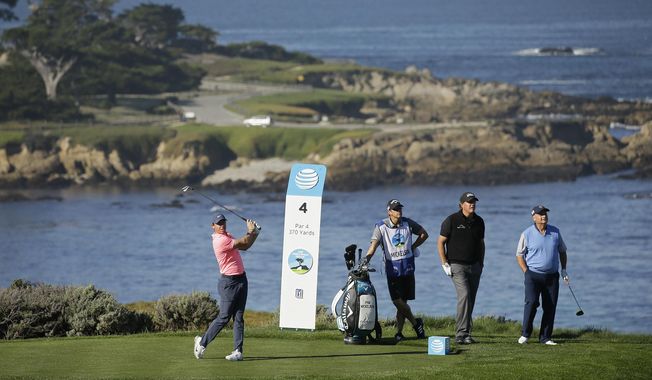Rory McIlroy, of Northern Ireland, hits from the fourth tee of the Spyglass Hill Golf Course during the first round of the AT&amp;T Pebble Beach National Pro-Am golf tournament Feb. 8, 2018, in Pebble Beach, Calif. Looking on from left are caddie Tim Mickelson, Phil Mickelson and Jimmy Dunne III. Dunne was instrumental in getting the PGA Tour to meet with the head of Saudi Arabia&#x27;s wealth fund. (AP Photo/Eric Risberg, File)