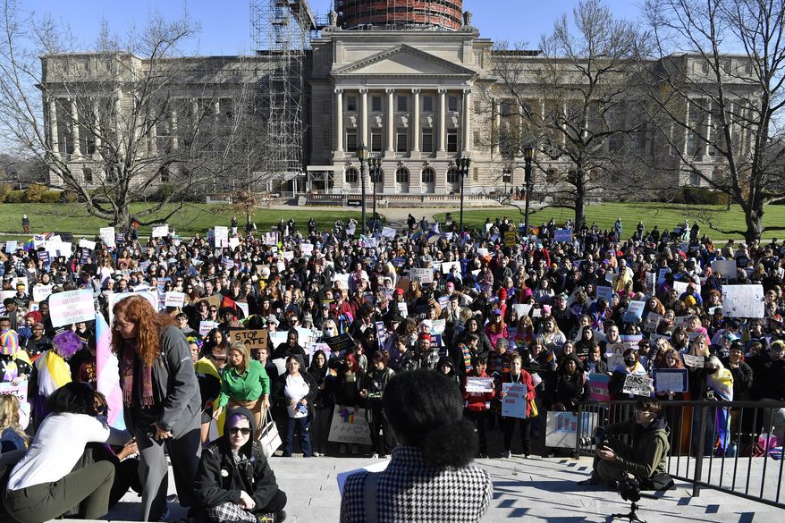 A group of protesters gather on the lawn of the Kentucky State Capitol to voice their opposition to the Transgender Health Bill in Frankfort, Ky., on March 29, 2023. A new dispute has erupted in June over Kentucky's sweeping transgender law, revolving around one word in a section banning sex education topics — including sexual orientation — from discussion in classrooms. (AP Photo/Timothy D. Easley, File)