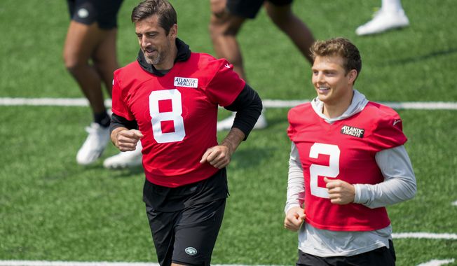 CORRECTS CITY AND STATE - New York Jets quarterback Aaron Rodgers (8) performs stretching drills with quarterback Zach Wilson (2) at the NFL football team&#x27;s practice facility, Tuesday, May 23, 2023, in Florham Park, N.J. (AP Photo/John Minchillo)