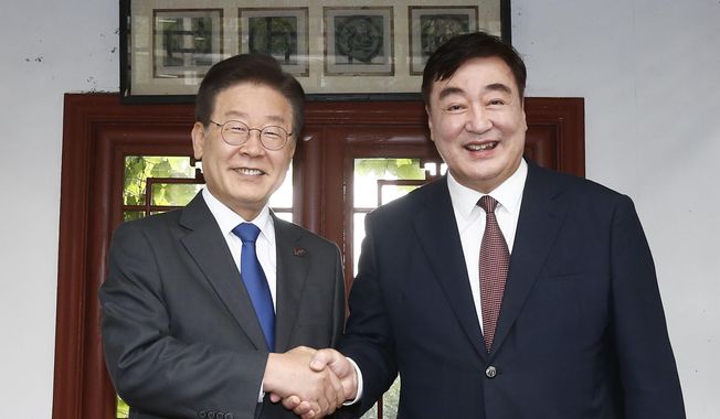 Chinese Ambassador to South Korea Xing Haiming, right, shakes hands with South Korea&#x27;s main opposition Democratic Party leader Lee Jae-myung before their dinner meeting at the Chinese ambassador&#x27;s residence in Seoul, South Korea, Thursday, June 8, 2023. South Korea’s Foreign Ministry summoned China&#x27;s ambassador on Friday to protest comments he made accusing Seoul of tilting toward the United States and away from China, as competition between Washington and Beijing for global influence intensifies.(Yonhap via AP)