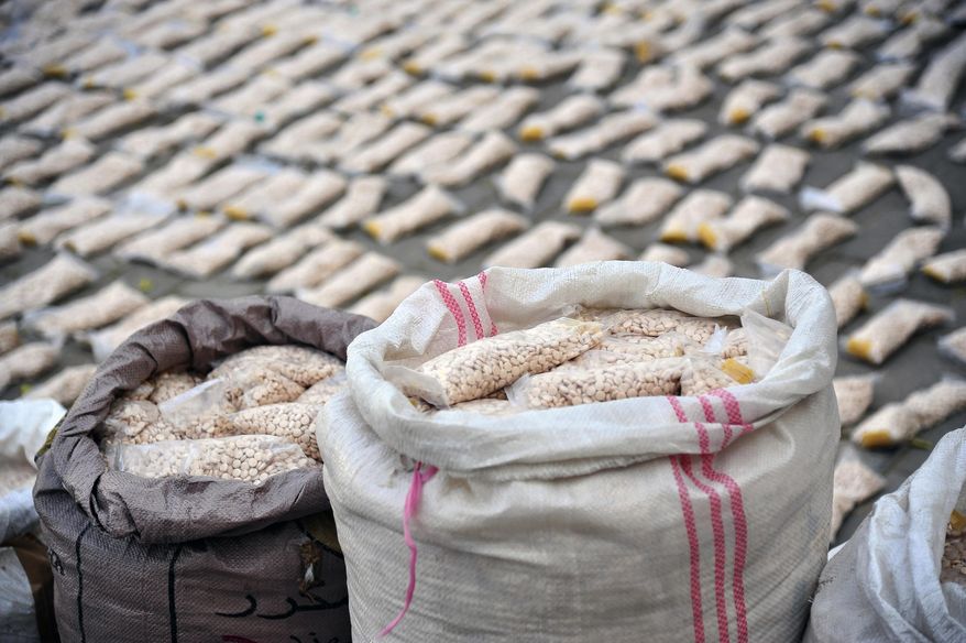 In this file photo released by the Syrian official news agency SANA, Syrian authorities display Captagon pills, in rural Damascus, Syria, Tuesday, Nov. 30, 2021. A little white pill has given Syrian President Bashar Assad powerful leverage with his Arab neighbors, who have been willing to bring him out of pariah status in hopes he will stop the flow of highly addictive Captagon amphetamines out of Syria. (SANA via AP, File)