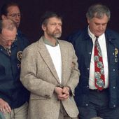 Theodore Kaczynski looks around as U.S. Marshals prepare to take him down the steps at the federal courthouse to a waiting vehicle on June 21, 1996, in Helena, Mont. A spokesperson for the Bureau of Prisons told The Associated Press that Kaczynski, known as the “Unabomber,” has died in federal prison. The cause of death was not immediately known. (AP Photo/Elaine Thompson, File)
