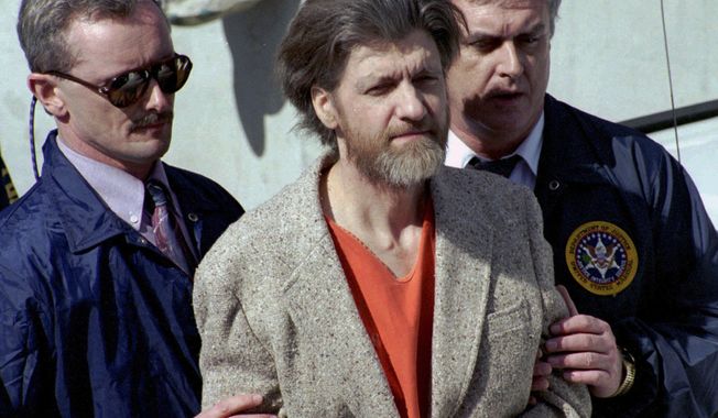 Theodore "Ted" Kaczynski is flanked by federal agents as he is led to a car from the federal courthouse in Helena, Mont., April 4, 1996. Kaczynski, known as the “Unabomber,” who carried out a 17-year bombing campaign that killed three people and injured 23 others, died by suicide, four people familiar with the matter told The Associated Press, Sunday, June 11, 2023. (AP Photo/John Youngbear, File)