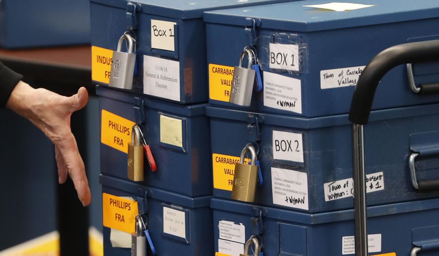 In this Nov. 12, 2018 file photo, ballot boxes are brought into for a ranked-choice voting tabulation in Augusta, Maine. A proposal that would make Maine the second state in the country with ranked choice voting for governor is due for a vote. Maine and Alaska both use the ranked voting format for congressional and presidential elections. (AP Photo/Robert F. Bukaty, File)