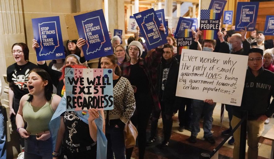 Protesters stand outside of the Senate chamber at the Indiana Statehouse on Feb. 22, 2023, in Indianapolis. A federal judge is scheduled Wednesday, June 14, to hear arguments in a lawsuit seeking to block an Indiana law banning doctors from providing puberty blockers, hormones and gender-affirming surgeries to minors. (AP Photo/Darron Cummings, File)