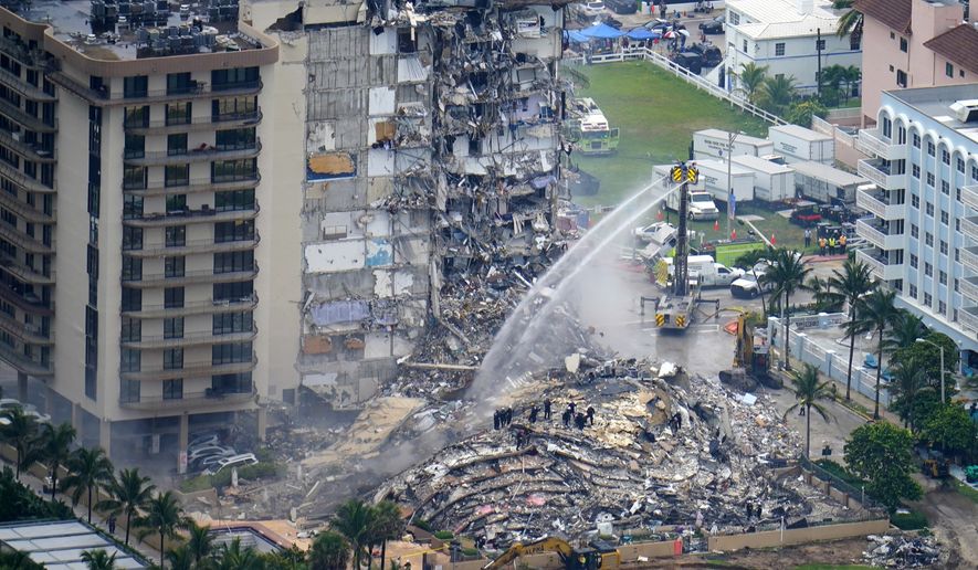 Rescue personnel work at the remains of the Champlain Towers South condo building, June 25, 2021, in Surfside, Fla. The swimming pool deck of the beachfront South Florida condominium where 98 people died when the building collapsed two years ago failed to comply with the original codes and standards, with many areas of severe strength deficiency, federal investigators said Thursday, June 15, 2023. (AP Photo/Gerald Herbert, File)