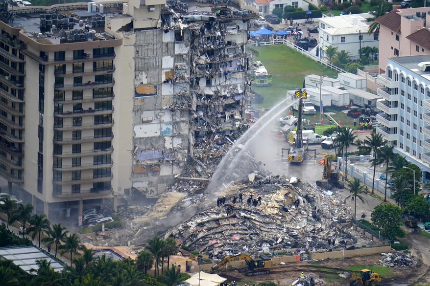 Rescue personnel work at the remains of the Champlain Towers South condo building, June 25, 2021, in Surfside, Fla. The swimming pool deck of the beachfront South Florida condominium where 98 people died when the building collapsed two years ago failed to comply with the original codes and standards, with many areas of severe strength deficiency, federal investigators said Thursday, June 15, 2023. (AP Photo/Gerald Herbert, File)