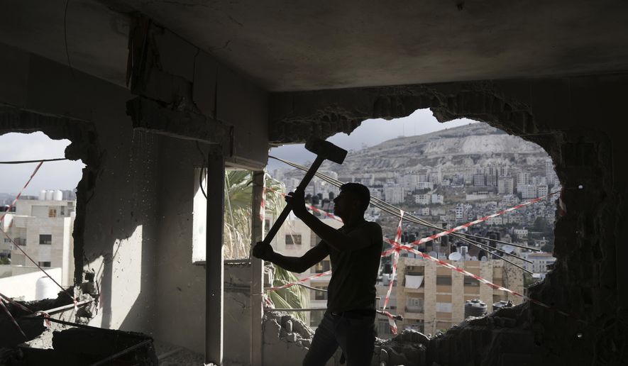 A Palestinian clears rubble after Israeli forces demolished the home of Osama Tawil, who was arrested in February for killing an Israeli soldier last year, in Nablus, Thursday, June 15, 2023. During the demolition operation, the Israeli military said troops operating in Nablus came under fire and fired back. A Palestinian man was killed, health officials said. (AP Photo/Nasser Nasser)
