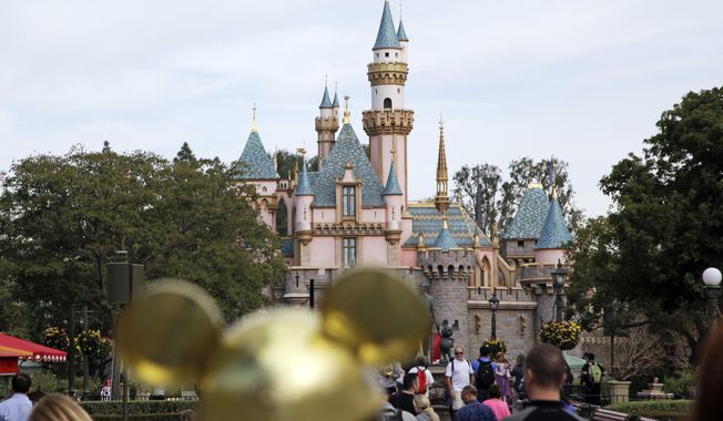 In this Jan. 22, 2015, file photo, visitors walk toward the Sleeping Beauty&#x27;s Castle in the background at Disneyland Resort in Anaheim, Calif. (AP Photo/Jae C. Hong, File)