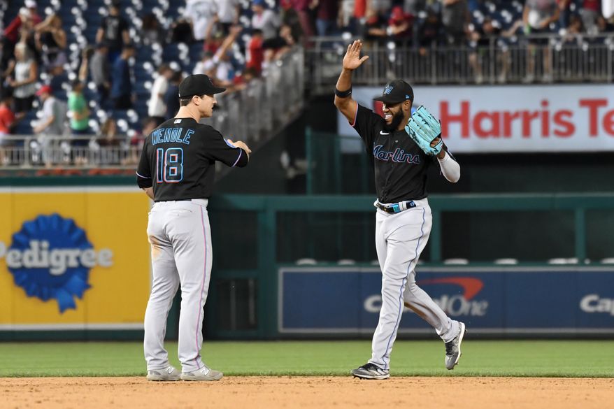 Miami Marlins left fielder Bryan De La Cruz (14) about to slap hands with shortstop Joey Wendle (18) after the team’s 6-5 victory over the Washington Nationals at Nationals Park in Washington D.C., June 16, 2023. (Photo by Billy Sabatini/All-Pro Reels)