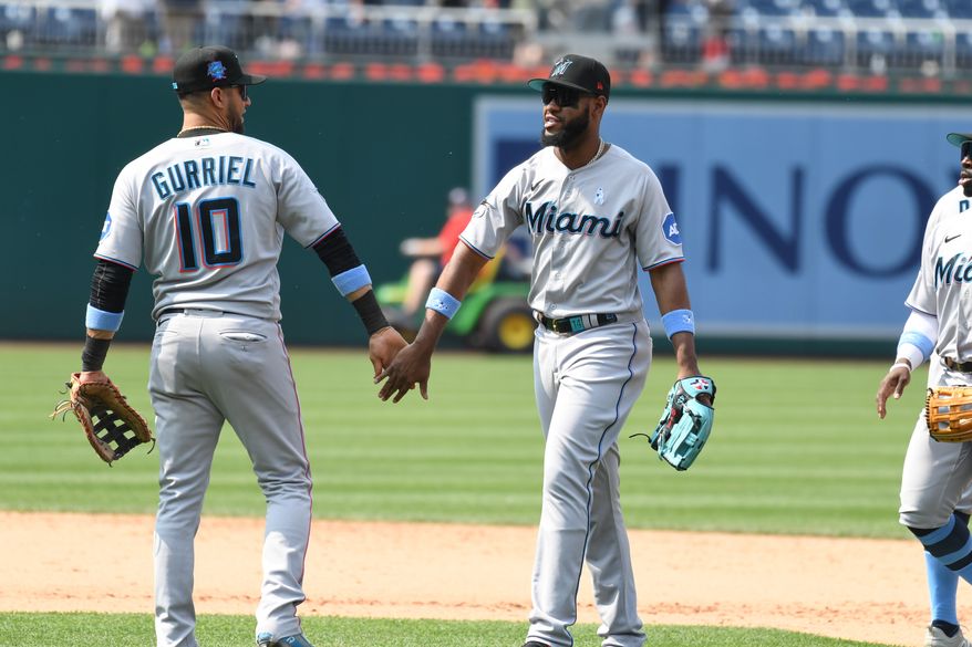 Miami Marlins first baseman Yuli Gurriel (10) slaps hands with left fielder Bryan De La Cruz (14) after the team’s 4-2 victory over the Washington Nationals at Nationals Park in Washington D.C., June 18, 2023. (Photo by Billy Sabatini/All-Pro Reels)