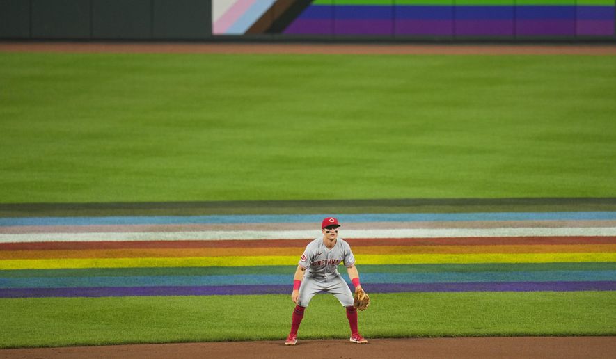 Cincinnati Reds shortstop Matt McLain stands near flags in honor of Pride Night in the seventh inning of a baseball game against the Baltimore Orioles, Wednesday, June 28, 2023, in Baltimore. (AP Photo/Julio Cortez)