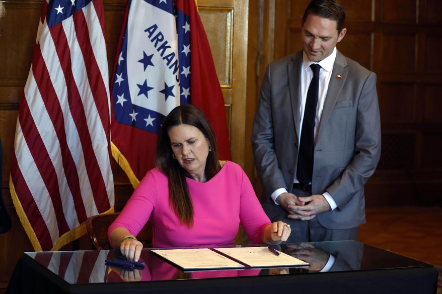 Arkansas Gov. Sarah Huckabee Sanders signs a bill requiring age verification before creating a new social media account as Sen. Tyler Dees, R-Siloam Springs, looks on during a signing ceremony, Wednesday, April 12, 2023, at the state Capitol in Little Rock, Ark. , NetChoice, a tech industry trade group, is suing Arkansas over its law requiring parental permission for minors to create new social media accounts. (Thomas Metthe/Arkansas Democrat-Gazette via AP)