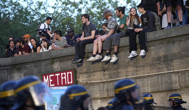 Police patrol as youths gather on Concorde square during a protest in Paris, France, Friday, June 30, 2023. French President Emmanuel Macron urged parents Friday to keep teenagers at home and proposed restrictions on social media to quell rioting spreading across France over the fatal police shooting of a 17-year-old driver. (AP Photo/Lewis Joly)