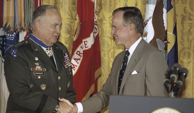 President George H.W. Bush congratulates Desert Storm commander Gen. Norman Schwarzkopf after presenting him with the medal of freedom at the White House in Washington, July 4, 1991. Bush also bestowed the medal on Joint Chiefs of Staff Chairman Gen. Colin Powell. (AP Photo/Doug Mills, File)