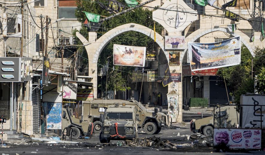 Army vehicles are seen during an Israeli military raid on the militant stronghold of the Jenin refugee camp in the occupied West Bank, Tuesday, July 4, 2023. Palestinian health officials said at least 10 Palestinians were killed in Israeli raids and airstrikes. Army spokesman Rear Adm. Daniel Hagari said Israel launched the operation because some 50 attacks over the past year had emanated from Jenin. (AP Photo/Majdi Mohammed)