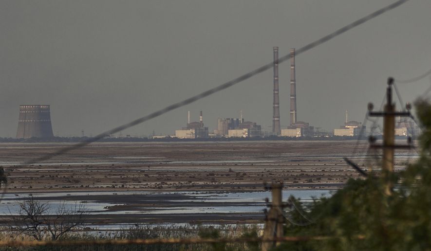 The Zaporizhzhia nuclear power plant, Europe&#x27;s largest, is seen in the background of the shallow Kakhovka Reservoir after the dam collapse, in Energodar, Russian-occupied Ukraine, Tuesday, June 27, 2023. Ukraine and Russia accused each other Wednesday, July 5, 2023, of planning to attack the power plant, which is occupied by Russian troops, but neither side provided evidence to support their claims. (AP Photo/Libkos, File)