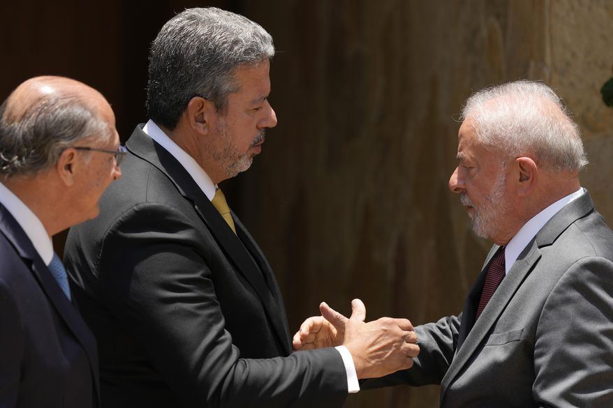 Brazilian President-elect Luiz Inacio Lula da Silva, right, shakes hands with Chamber of Deputies President Arthur Lira, next to his Vice President-elect Geraldo Alckmin, after a meeting before Lula's inauguration in Brasilia, Brazil, Nov. 9, 2022. Brazil’s lower house of Congress has approved a major reform of the nation’s notoriously complicated tax system on July 7, 2023, showing compromise is possible between Congress and Lula's government. (AP Photo/Eraldo Peres, File)