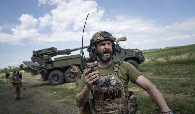 A Ukrainian serviceman Dmytro speaks by radio to his team before firing a self-propelled howitzer &quot;Bohdana&quot; towards Russian positions near Bakhmut, Ukraine, Friday, July 7, 2023. (AP Photo/Evgeniy Maloletka)