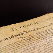 The Declaration of Independence and Constitution of the United States of America, isolated on black background. File photo credit: Roberti via Shutterstock.