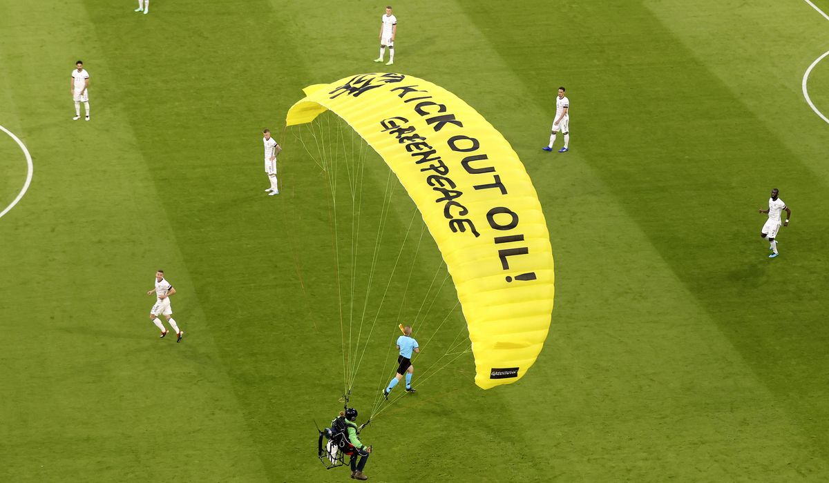 NextImg:Greenpeace activists fined for crash-landing a parachute in stadium before Germany-France match