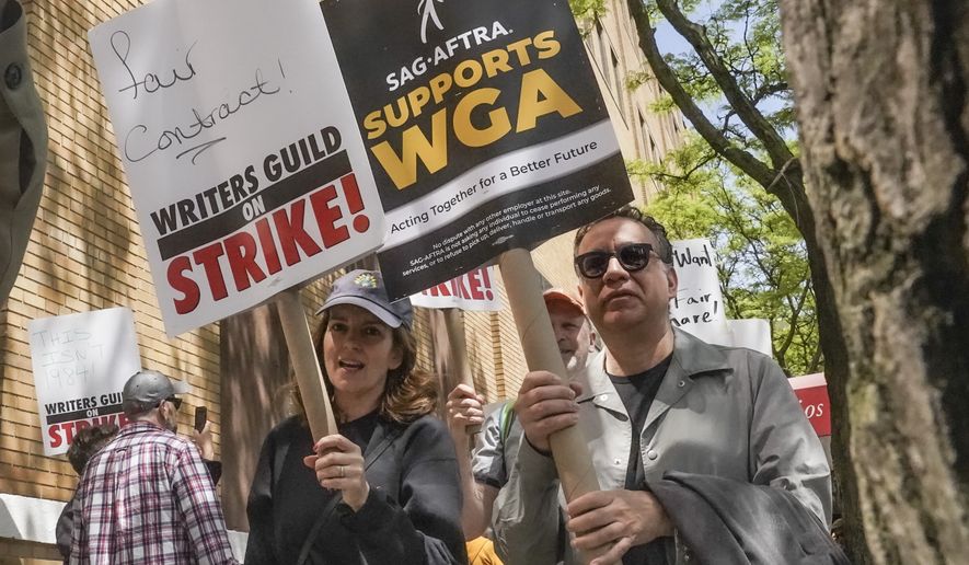 Actors and comedians Tina Fey, center, and Fred Armisen, right, join striking members of the Writers Guild of America on the picket line during a rally outside Silvercup Studios, Tuesday, May 9, 2023, in New York. Unionized Hollywood actors on the verge of a strike have agreed to allow a last-minute intervention from federal mediators but say they doubt a deal will be reached by a negotiation deadline late Wednesday, July 12, 2023. (AP Photo/Bebeto Matthews, File)