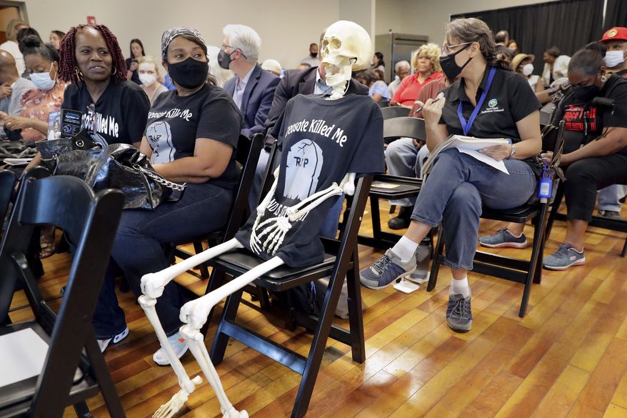 A prop skeleton dressed iin a "Creosote Killed Me" T-shirt sits in the middle of the seating during a community meeting put on by the Texas Commission on Environmental Quality, held at the Deluxe Theater Tuesday, May 3, 2022 in Houston. Houston plans to spend millions of dollars to relocate residents from neighborhoods located near a rail yard polluted by a cancer-linked wood preservative that has been blamed for an increase in cancer cases, the city’s mayor announced Thursday, July 13, 2023. (Michael Wyke/Houston Chronicle via AP)