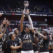 Las Vegas Aces&#x27; A&#x27;ja Wilson holds up the championship trophy as she celebrates with teammates after their win in the WNBA basketball finals against the Connecticut Sun, Sept. 18, 2022, in Uncasville, Conn. (AP Photo/Jessica Hill) **FILE**