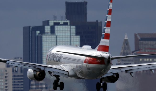 An American Airlines plane lands at Logan International Airport, Thursday, Jan. 26, 2023, in Boston. American Airlines earnings are reported on Thursday. (AP Photo/Michael Dwyer, File)