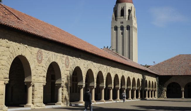 People walk on the Stanford University campus beneath Hoover Tower in Stanford, Calif., on March 14, 2019. Anonymous comments with racist, sexist and abusive messages that were posted for years on a jobs-related website for economists originated from numerous leading U.S. universities, including Harvard, Stanford, and the University of Chicago, according to research released Thursday. (AP Photo/Ben Margot, File)