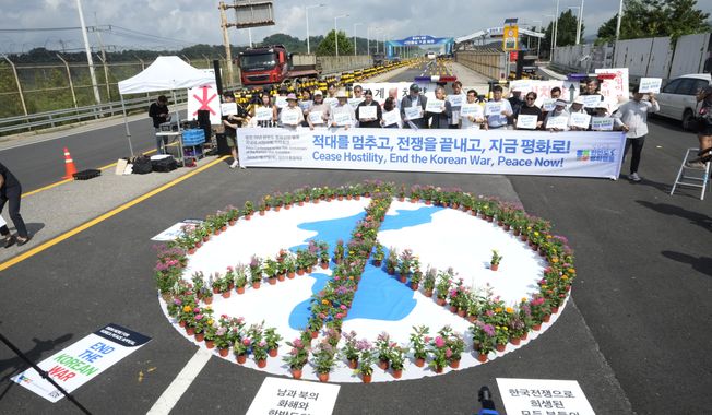 Anti-war activists stage a rally commemorating the 70th anniversary of the Korean War Armistice Agreement near the Unification Bridge, which leads to the Panmunjom in the Demilitarized Zone in Paju, South Korea, Thursday, July 27, 2023. (AP Photo/Ahn Young-joon)