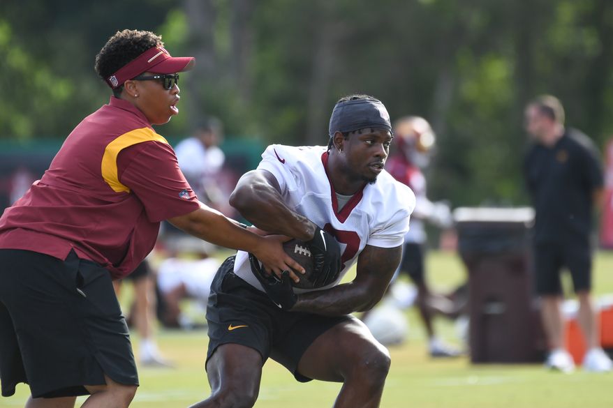 Washington Commanders running back Brian Robinson Jr. (8) taking a handoff from assistant running backs coach Jennifer King during the fourth day of training camp at the OrthoVirginia Training Center at Commanders Park in Ashburn, Virginia, July 29, 2023. (Photo by Billy Sabatini)