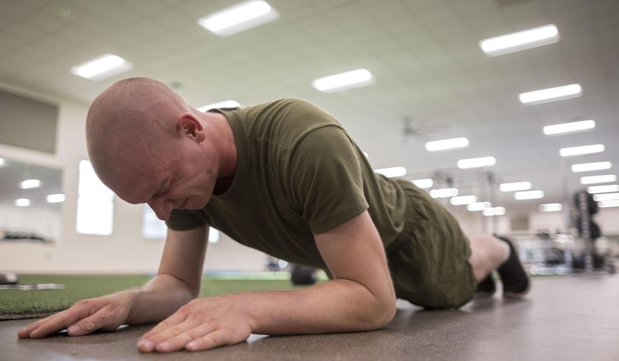 A U.S. Marine Corps recruit works out with a plank exercise during his physical therapy after sustaining an injury during training at the Marine Corps Recruit Depot, Wednesday, June 28, 2023, in Parris Island, S.C. (AP Photo/Stephen B. Morton)