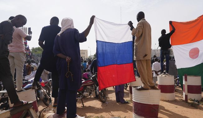 Nigeriens holding a Russian flag participate in a march called by supporters of coup leader Gen. Abdourahmane Tchiani in Niamey, Niger, Sunday, July 30, 2023. Days after after mutinous soldiers ousted Niger&#x27;s democratically elected president, uncertainty is mounting about the country&#x27;s future and some are calling out the junta&#x27;s reasons for seizing control. (AP Photo/Sam Mednick)