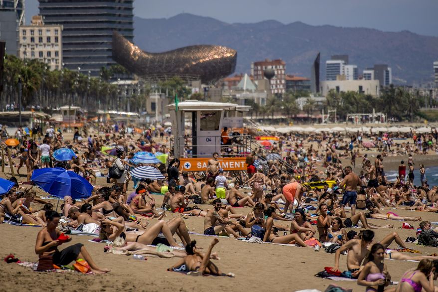 People sunbathe on the beach in Barcelona, Spain, Friday, July 9, 2021. Spain received 37.5 million international tourists in the first half of 2023, a 24% increase from the same period last year, the government announced Wednesday, Aug. 2, 2023. (AP Photo/Joan Mateu, File)