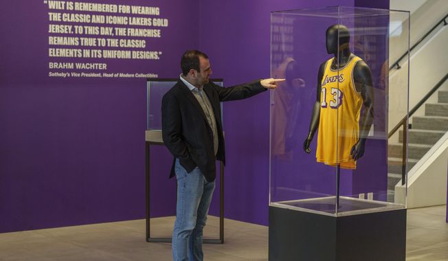 Sotheby&#x27;s Vice President Brahm Wachter looks at the display of Wilt Chamberlain&#x27;s 1972 NBA Finals &#x27;Championship Clinching&#x27; Jersey at Sotheby&#x27;s Los Angeles Gallery on Tuesday, Aug. 1, 2023, in Beverly Hills, Calif. The jersey is being offered along with a collection of memorabilia in an online sale Aug. 28-Sept. 27. (AP Photo/Damian Dovarganes)