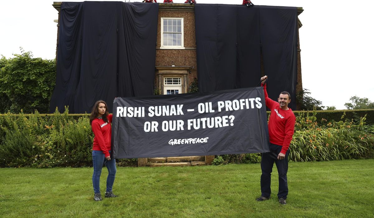 NextImg:Greenpeace demonstrators drape U.K. prime minister’s house in black to protest oil expansion