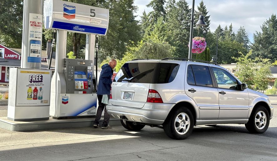 An attendant services a car at a gas station in Lake Oswego, Ore., Friday, July 28, 2023. In 1951, Oregon banned self-serve pumps at filling stations, being the only U.S. state besides New Jersey to do so. But now, the Oregon Legislature has decided that people across the state should be able to choose between having an attendant pump the gas or do it themselves. Gov. Tina Kotek signed the bill into law on Friday, Aug. 4, 2023, taking effect immediately. (AP Photo/Gillian Flaccus)