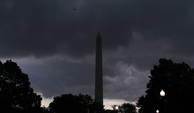 Storm clouds darken the sky over the Washington Monument, Monday, Aug. 7, 2023, in Washington. Thousands of federal employees were sent home early Monday as the Washington area faced a looming forecast for destructively strong storms, including tornadoes, hail and lightning. (AP Photo/Jacquelyn Martin)