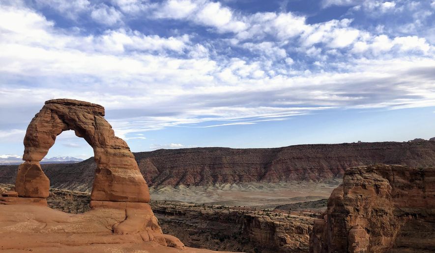 FILE - Delicate Arch is seen at Arches National Park on April 25, 2021, near Moab, Utah. A Texas man whose body was found in Utah’s Arches National Park is believed to have died of heat stroke while on a trip to spread his father’s ashes. Hendricks, 66 of Austin, was hiking in the park and likely became disoriented from a combination of heat, dehydration and high altitude, according to sister Ruth Hendricks Bough. (AP Photo/Lindsay Whitehurst, File)