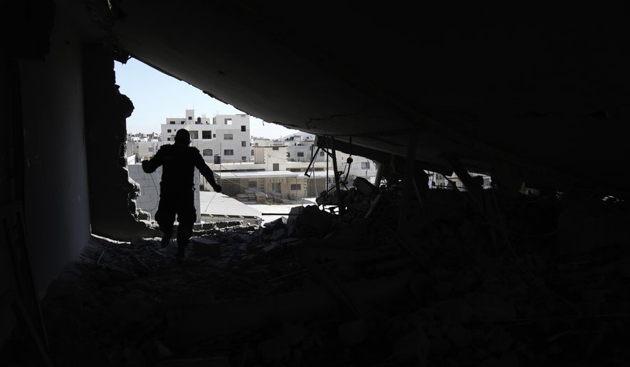 A Palestinian engineer inspects the home of a man accused of carrying out a deadly shooting attack earlier this year, after it was demlioshed by Israeli forces in the Askar refugee camp in the West Bank city of Nablus, Tuesday, Aug. 8, 2023. The Israeli military said its forces entered the camp early Tuesday and demolished the apartment of 49-year-old Abdul Fattah Kharushah, an alleged member of the Hamas militant group who was suspected of shooting and killing two Israeli brothers in the town of Hawara earlier this year. (AP Photo/Nasser Nasser)