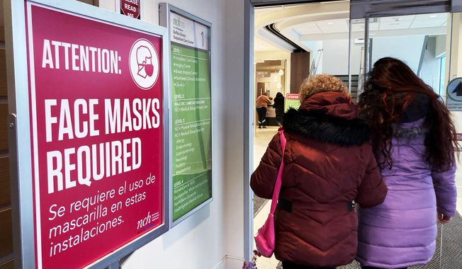 A sign announcing a face mask requirement is displayed at a hospital in Buffalo Grove, Ill., Friday, Jan. 13, 2023. COVID-19 hospital admissions are inching upward in the United States since early July 2023. It&#x27;s a small-scale echo of the three previous summers. (AP Photo/Nam Y. Huh)